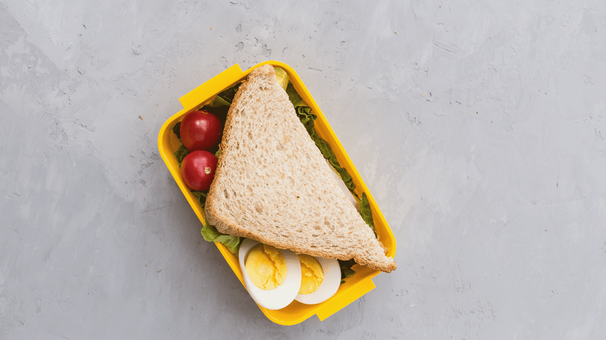 sandwich tomatoes lettuce and eggs in yellow lunch box