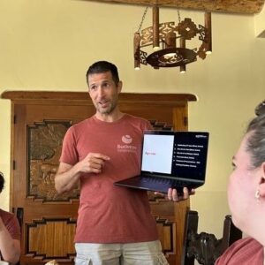 man pointing at laptop in his hands to make a point