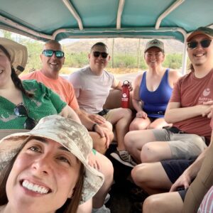 7 people smiling in a jeep