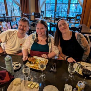 Three people sitting at a table and smiling at the camera