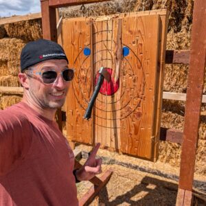 Man takes selfie after getting a bullseye in axe-throwing competition