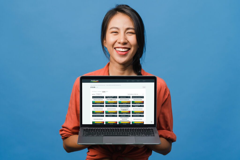 Smiling woman holding laptop with screen facing camera